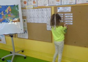 Dziewczynka przyczepia na tablicy nazwę kraju należącego do Unii Europejskiej.